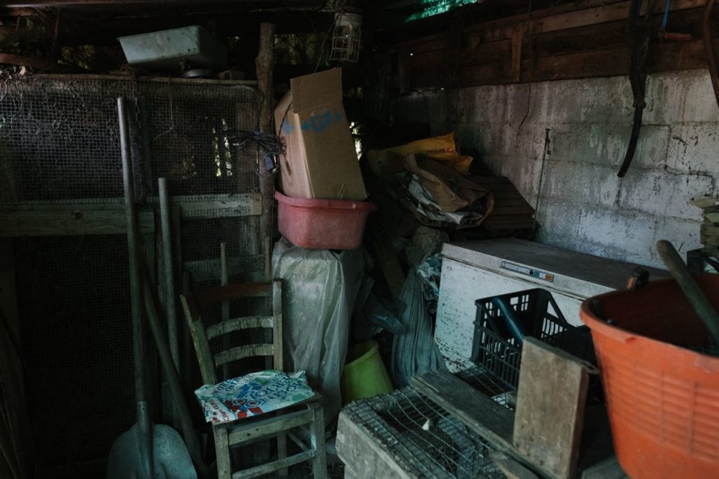Busy room in a backyard shack Full of old dirty objects