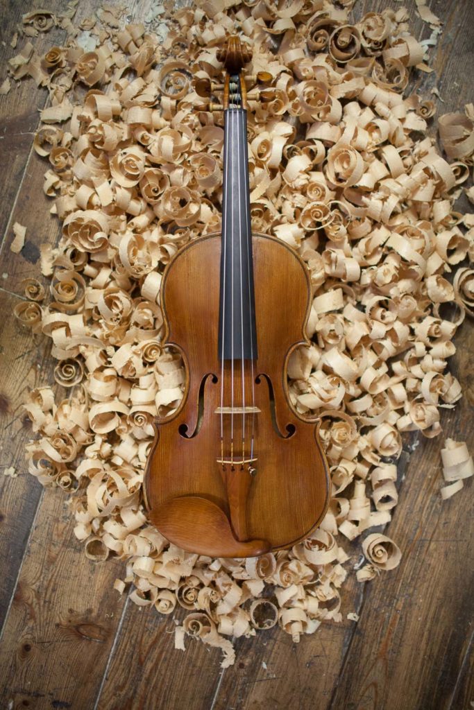Still life of a Handmade Violin on the Floor with Wooden Chips