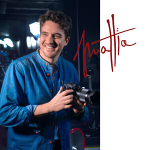 Photographer and Director Mattia Pelizzari's portrait holding a camera on a set