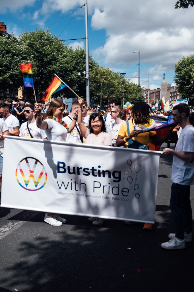 Volkswagen Ireland team marching at Dublin Pride parade, holding a “Bursting with Pride” banner.